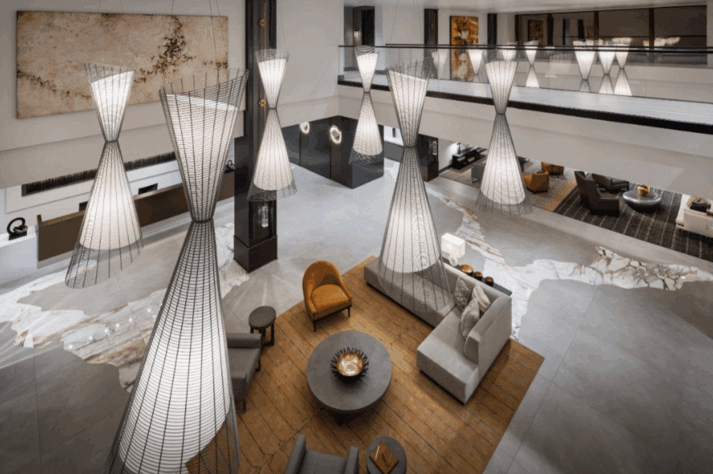 Stylish hallway with patterned carpet, wood accent walls, and sculptural lighting.